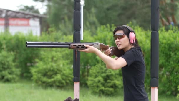 mladá krásná dívka střílí létající cíl na otevřené střelnici, past střelba - Záběry, video