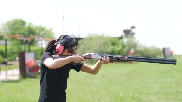 молодая красивая девушка стреляет летающей мишенью на открытом стрельбище, ловушка стрельбы
 - Кадры, видео