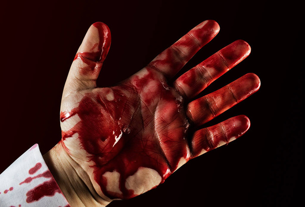Mannelijke bloedige spetterde hand in shirt. - Foto, afbeelding
