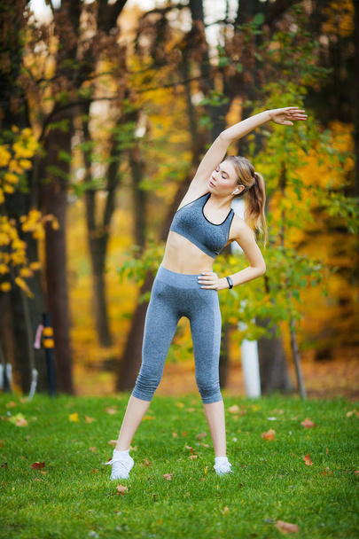 Fitness. Woman doing stretching exercise on park - Foto, immagini