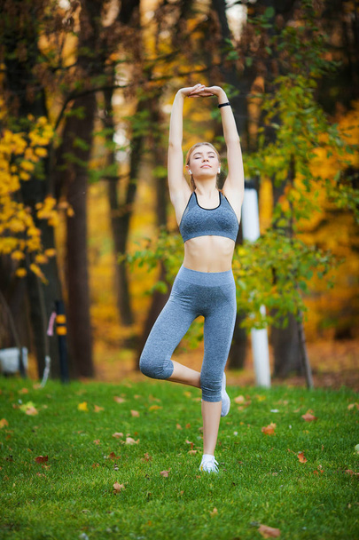 Fitness. Beautiful young woman doing exercises in the park - Photo, Image