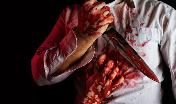 Άντρας με λευκό ματωμένο πουκάμισο που κρατά το μαχαίρι της κουζίνας. - Φωτογραφία, εικόνα