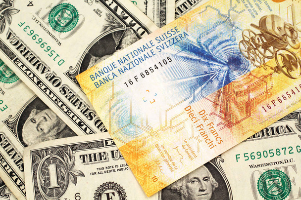 Um amarelo, nota de dez francos suíços da Suíça fechar em macro com notas de um dólar americano
 - Foto, Imagem