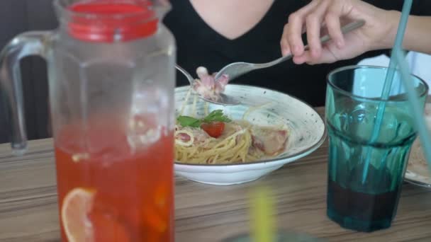 boy eating spaghetti in a restaurant with a fork and spoon - Video, Çekim