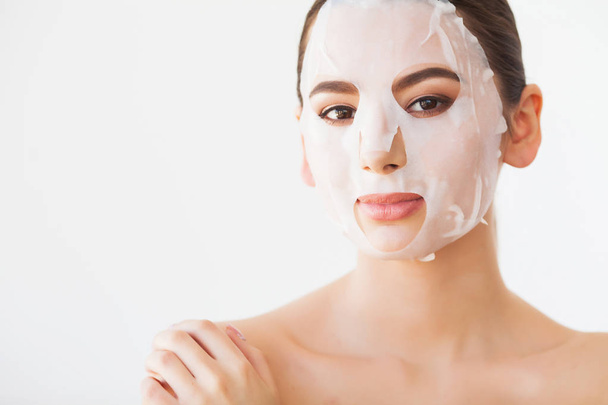 Cuidado com a pele. Jovem fêmea removendo máscara da pele facial. Mulher beleza rosto
 - Foto, Imagem