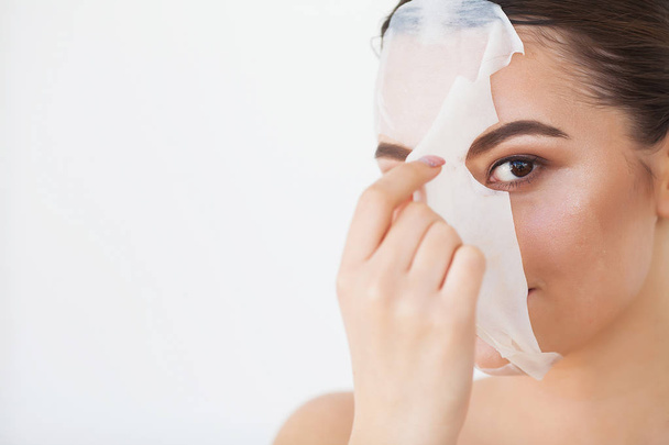 Περιποίηση δέρματος. Νεαρή γυναίκα αφαίρεση μάσκα από το δέρμα του προσώπου. Γυναικείο πρόσωπο ομορφιάς - Φωτογραφία, εικόνα