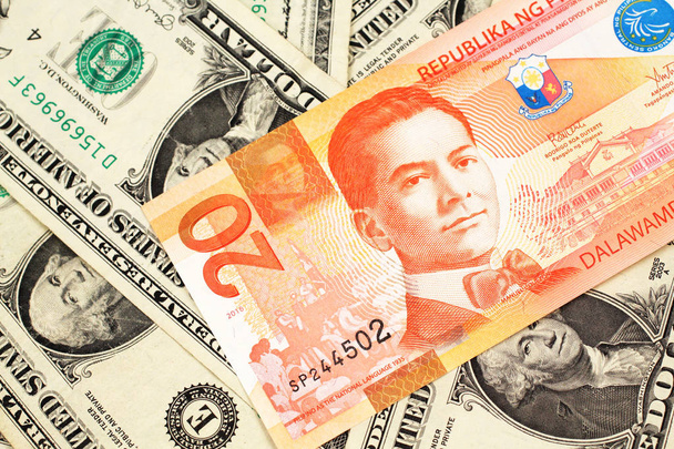 Un billet de banque orange de vingt pisos des Philippines avec des billets d'un dollar américain près en macro
 - Photo, image