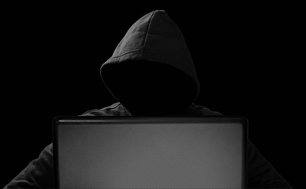 hacker with glowing mask behind notebook laptop in front of isol - Photo, Image