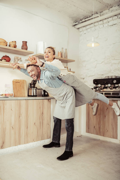Happy couple fooling around in their kitchen. - Фото, изображение