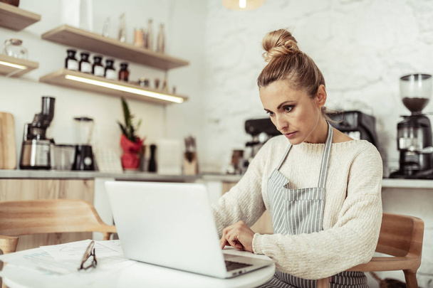 Focused cafe owner working at her laptop. - Fotografie, Obrázek