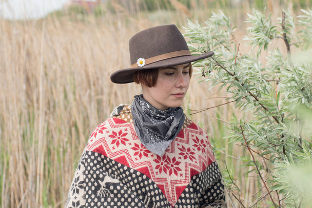 Giovane viaggiatrice in poncho e cappello passeggiata nei campi e fattoria
 - Foto, immagini