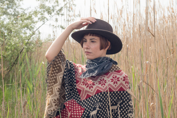 Na polích a na farmě mladá žena cestujícímu v Ponchu a Hat pěšky - Fotografie, Obrázek