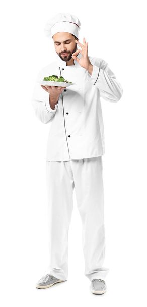 Pohledný mužský kuchař se salátem na bílém pozadí - Fotografie, Obrázek