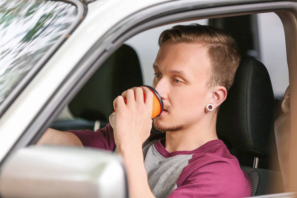 Bonito homem bebendo café no carro
 - Foto, Imagem