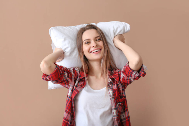 Young woman with pillow on color background - Photo, Image