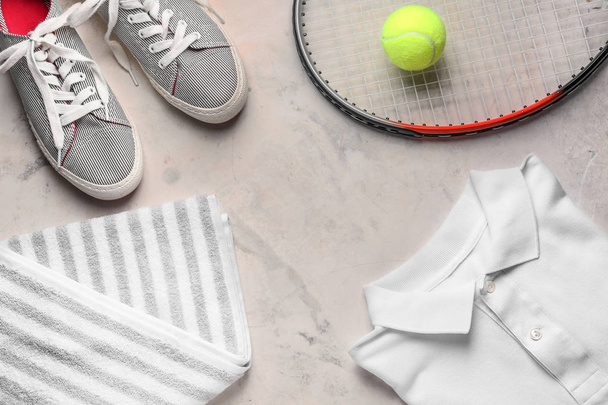 Tennismaila, kengät, vaatteet, pyyhe ja pallo harmaalla pohjalla
 - Valokuva, kuva