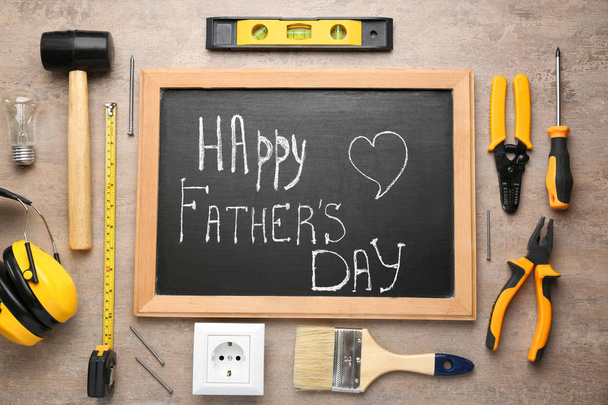 Různé nástroje a tabule s textem "den šťastného otce" na dřevěném pozadí - Fotografie, Obrázek