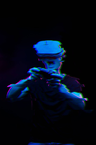 Hombre con auriculares de realidad virtual está jugando juego. Imagen con efecto glitch
. - Foto, imagen