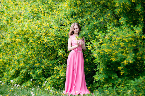 Vrouw in bloeiende gele zomertuin - Foto, afbeelding