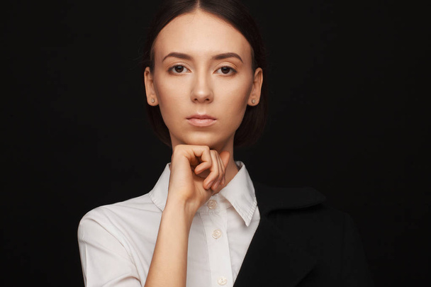 Portrait of a beautiful pacified woman in a white shirt and black jacket. Studio photo session - Фото, зображення