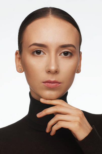 Portrait of a woman with an interesting appearance in a black turtleneck and with collected hair - Foto, afbeelding