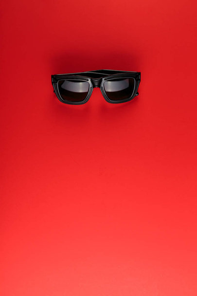 Sunglass on the red background with copy space.  Summer is coming concept. - Fotografie, Obrázek