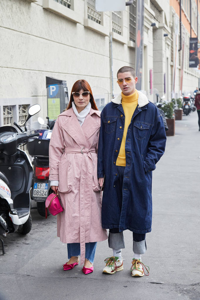 Woman with pink trench coat and man with denim long jacket before fashion Albino Teodoro show, Milan Fashion Week street style on February 21, 2018 in Milan. - Foto, Bild