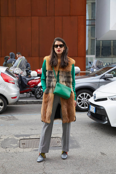 Woman with green leather bag and brown fur coat before fashion Albino Teodoro show, Milan Fashion Week street style on February 21, 2018 in Milan. - Photo, Image