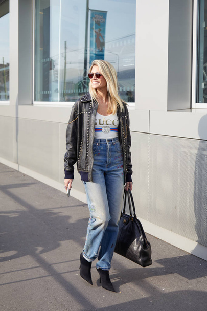 Woman with Gucci shirt and blue denim trousers before Gucci fashion show, Milan Fashion Week street style on February 21, 2018 in Milan. - 写真・画像