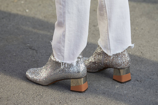 Mulher com sapatos de glitter de prata e calças de jeans rasgadas brancas antes do desfile de moda Gucci, estilo de rua Milan Fashion Week em fevereiro 21, 2018 em Milão
. - Foto, Imagem