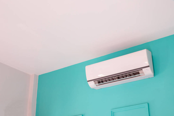 Modern air conditioner on blue wall in bedroom at home, nobody. - Photo, Image