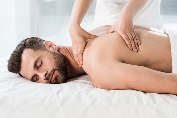 bel homme barbu couché sur la table de massage pendant le massage
  - Photo, image