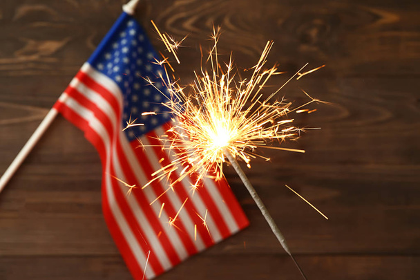 Sparkler en USA vlag op houten achtergrond. Onafhankelijkheidsdag viering - Foto, afbeelding