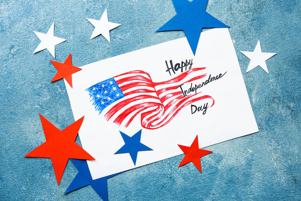 Papier blad met tekening van USA vlag en tekst gelukkig Onafhankelijkheidsdag op kleur achtergrond - Foto, afbeelding