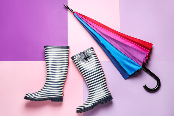 Stylowy parasol i gumowe buty na tle koloru - Zdjęcie, obraz
