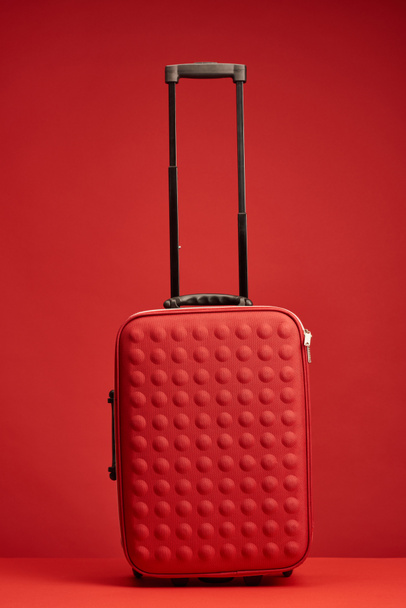 red colorful textured travel bag isolated on red  - Φωτογραφία, εικόνα