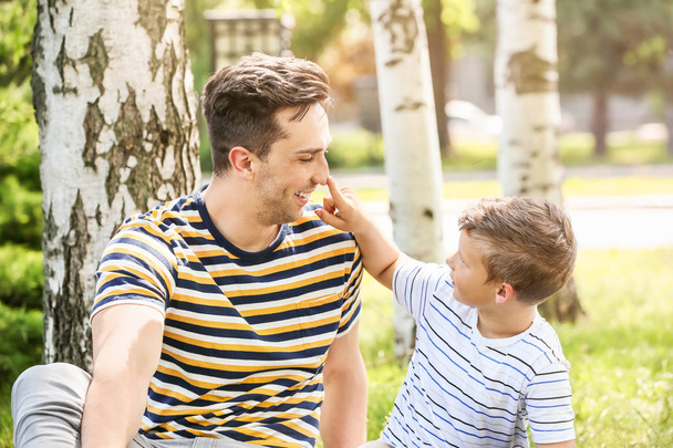 Portrait of happy father and son in park - Фото, изображение