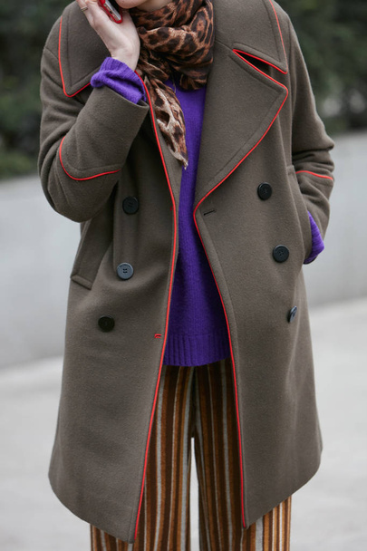 Woman with brown coat with red border and purple sweater before Giorgio Armani fashion show, Milan Fashion Week street style on January 15, 2018 in Milan. - Фото, изображение