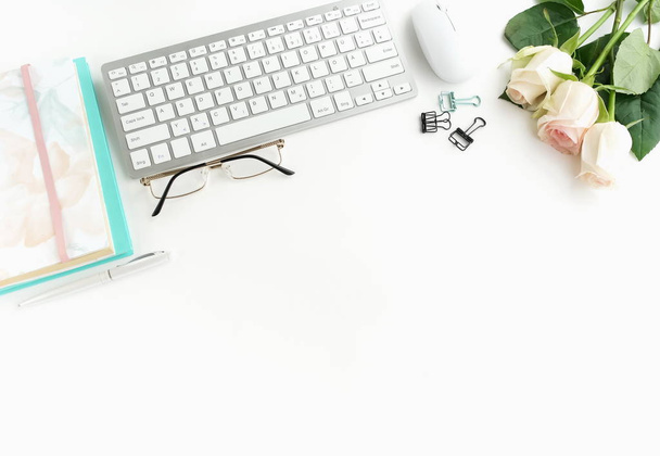 rose flowers, keyboard and notebooks on white tabletop - Φωτογραφία, εικόνα