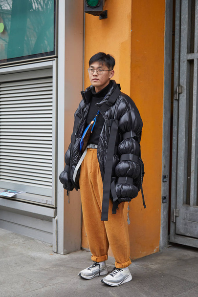 Mann mit schwarzer Moncler-Jacke und gelber Hose vor der Modenschau von Giorgio Armani, Mailänder Modewoche Streetstyle am 15. Januar 2018 in Mailand. - Foto, Bild
