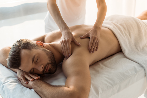 cropped view of woman doing massage to man with closed eyes  - Photo, Image
