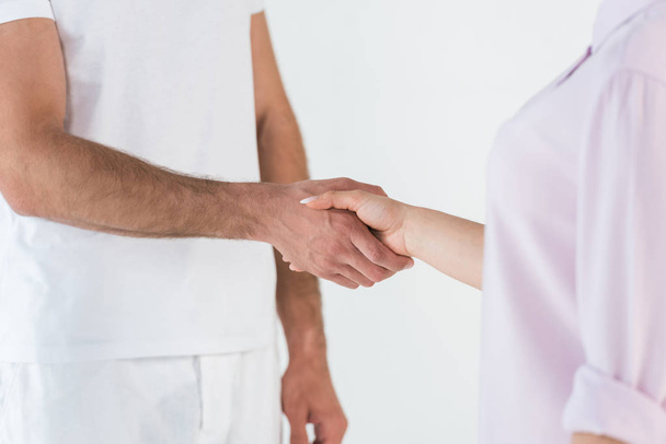 cropped view of man and woman shaking hands isolated on white  - Valokuva, kuva