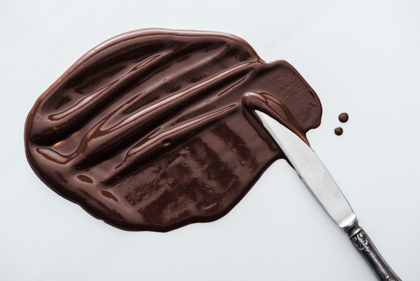 Vue du dessus du couteau de table avec chocolat noir fondu
 - Photo, image