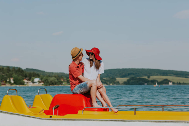 Retrato de pareja sonriente enamorada disfrutando del pedaleo en bote
. - Foto, imagen