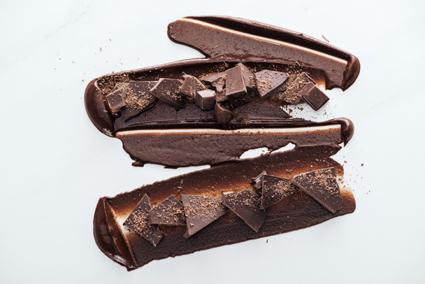 Top view of pieces of dark chocolate with liquid chocolate and cocoa powder - Φωτογραφία, εικόνα