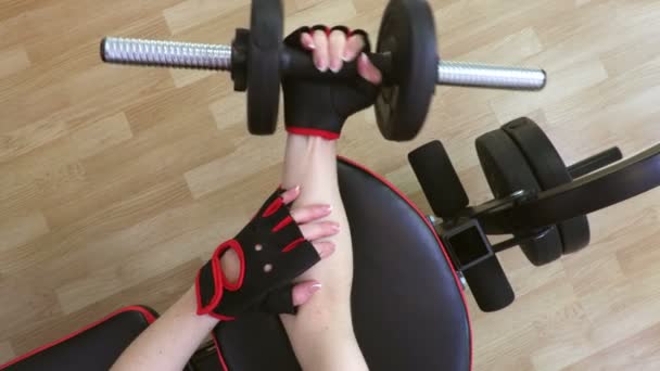 Γυναίκα στο γυμναστήριο κάνει ασκήσεις γυμναστικής με βαράκια για τους βραχίονες - Πλάνα, βίντεο