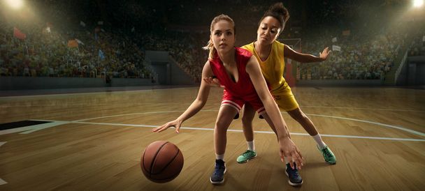 Kobiet koszykówki graczy walczyć o piłkę. Koszykarze na dużej profesjonalnej arenie podczas gry - Zdjęcie, obraz