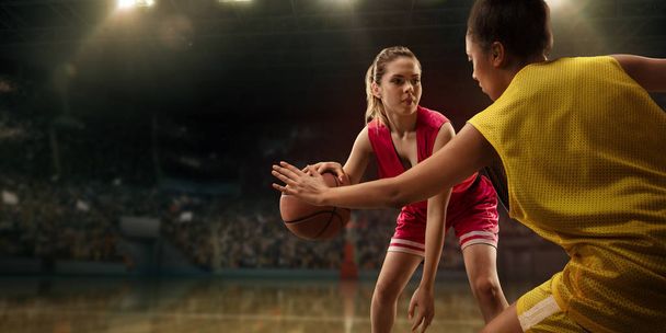 Vrouwelijke basketbal spelers vechten voor de bal. Basketbal spelers op de grote professionele Arena tijdens het spel - Foto, afbeelding