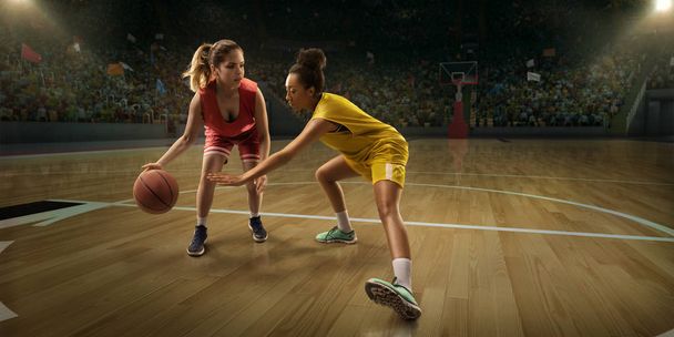 Női kosárlabda játékos harcot a labdát. Kosárlabda játékosok a nagy szakmai színtéren a játék során - Fotó, kép