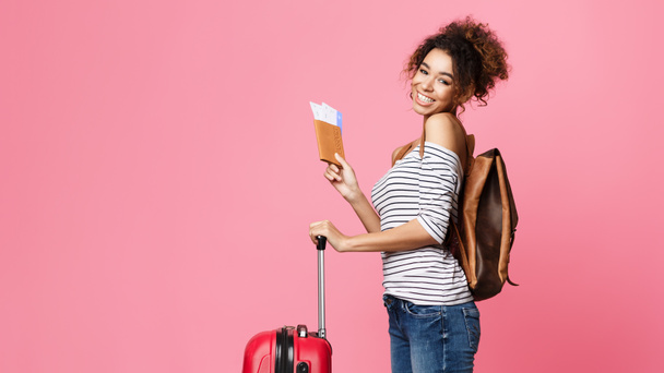 Reizen naar het buitenland. Gelukkige Afro vrouw met paspoort - Foto, afbeelding